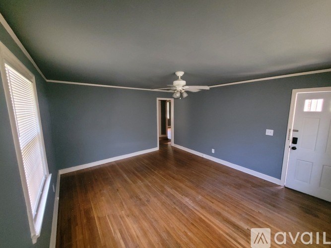 A room with wooden floors and a ceiling fan.