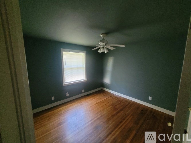 A room with a ceiling fan and a window.