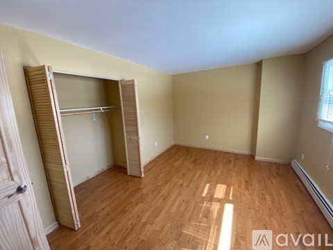 A room with wooden floors and a closet with a sliding door.
