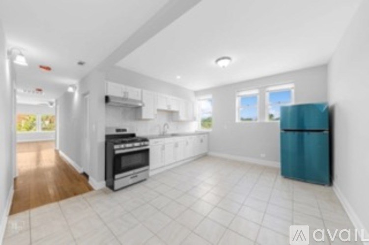 A kitchen with white cabinets and a blue fridge.