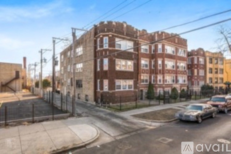 A street view of a residential area with apartment buildings and parked cars.