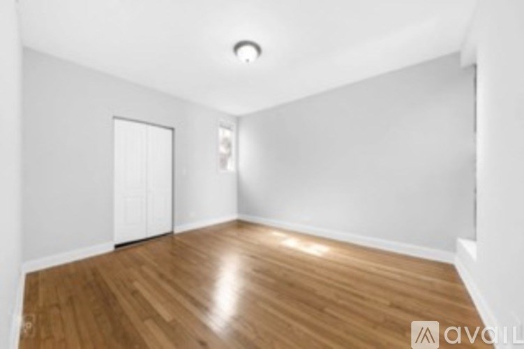 A room with wooden flooring and white walls.