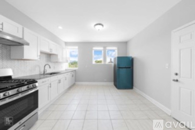 A kitchen with white cabinets and a black stove top.