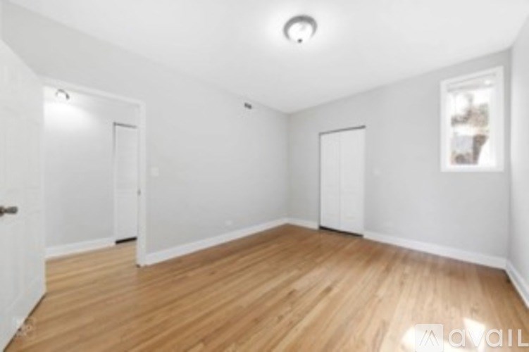 A room with wooden flooring and white walls.