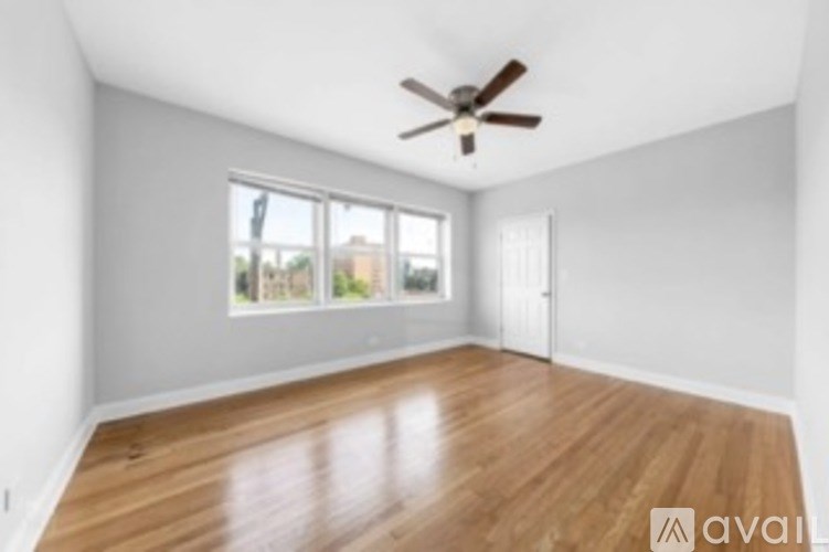 A room with wooden floors and a ceiling fan.