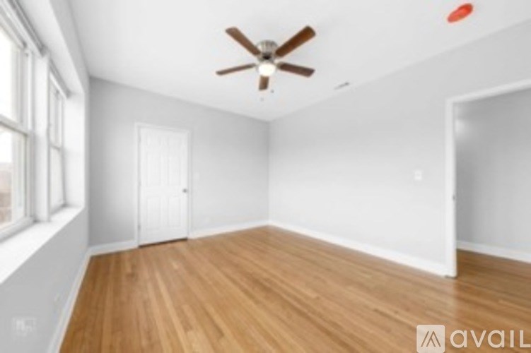 A room with wooden floors and a ceiling fan.