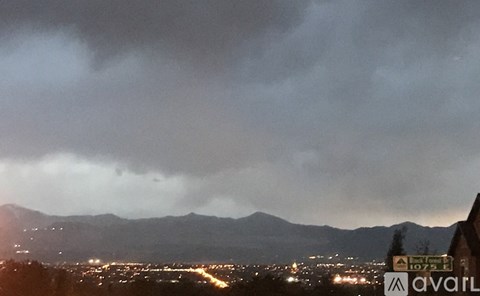 A dark stormy sky over a city at night.