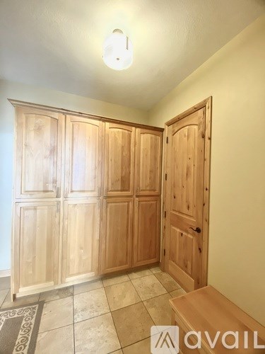 A room with wooden cupboards and a bench.