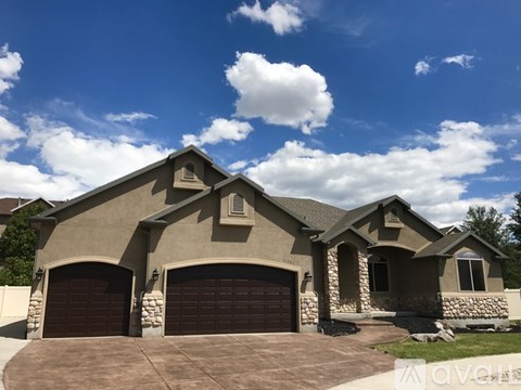 A house with a brown garage door and a stone wall.