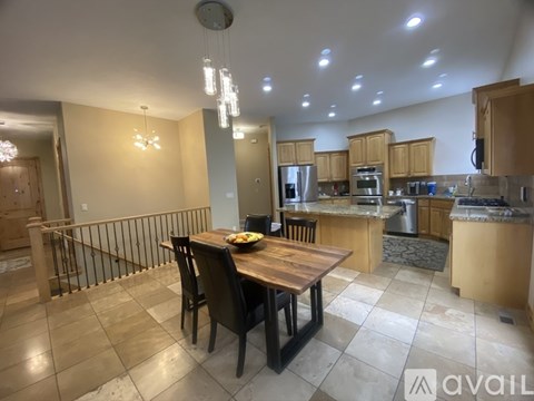 A kitchen with a dining table and chairs in the foreground.