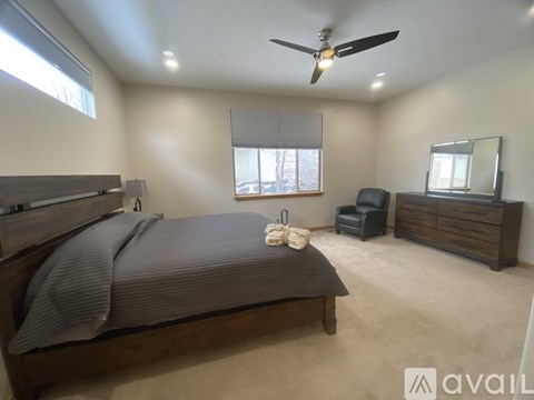 A bedroom with a bed, chair, and mirror.