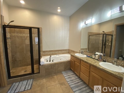A bathroom with a tub, sink, and mirror.