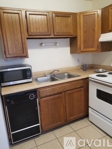 A kitchen with wooden cabinets and a white oven.