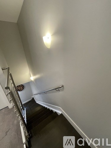 A staircase with a light on the wall.