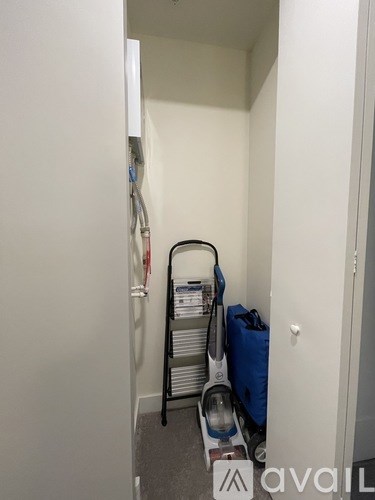 A vacuum cleaner is on the floor of a narrow room.