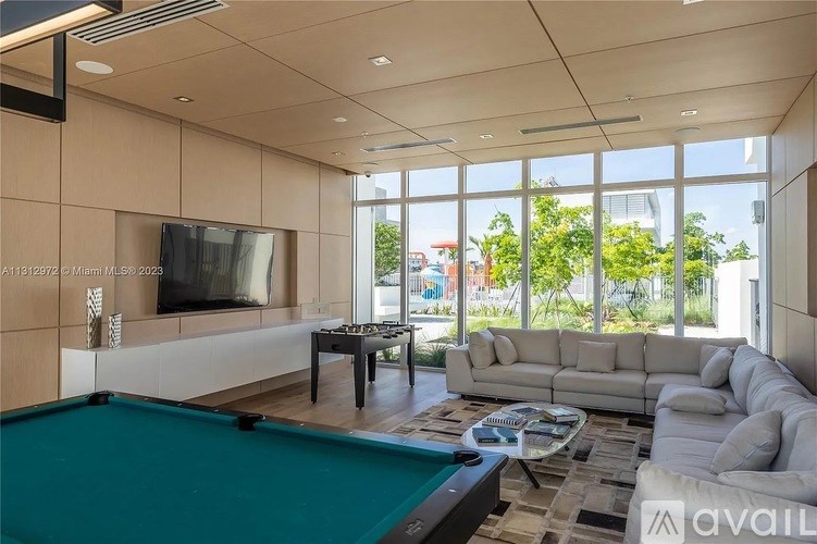 A modern living room with a pool table and a television.