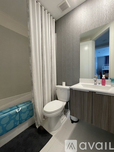 A bathroom with a toilet, sink, and shower curtain.