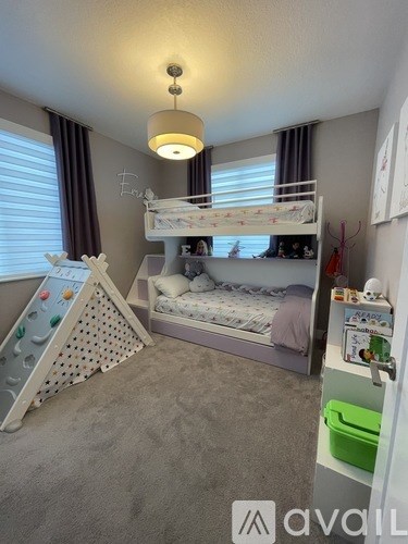 A child's bedroom with a bunk bed and a play area.