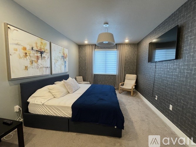 A bedroom with a large bed and a painting on the wall.