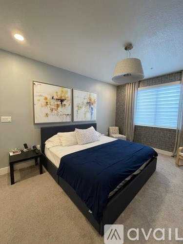 A bedroom with a large bed and a painting on the wall.