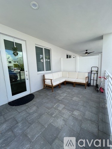 A patio with a grey floor and a white wall.