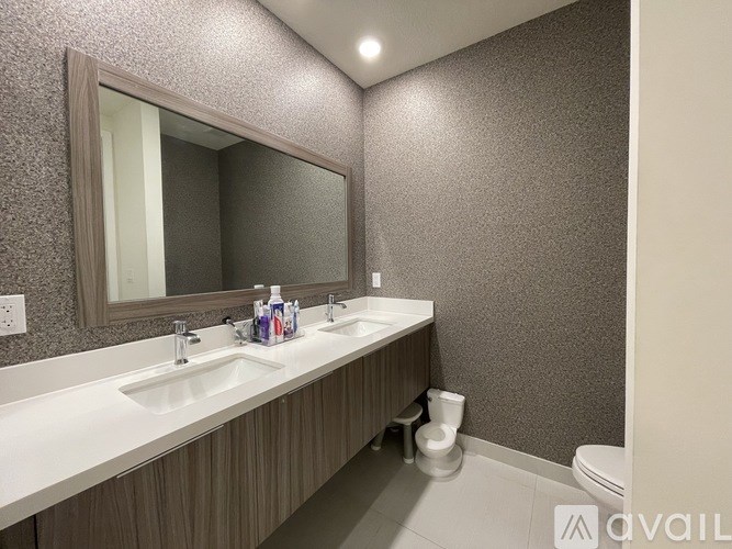 A bathroom with a white countertop and a large mirror above it.