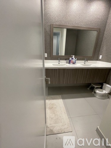 A bathroom with a toilet, sink, and mirror.
