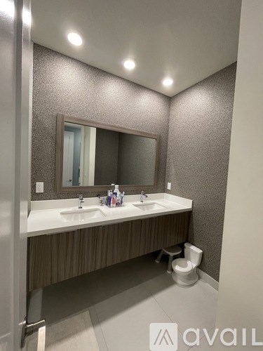 A bathroom with a sink, mirror, and toilet.