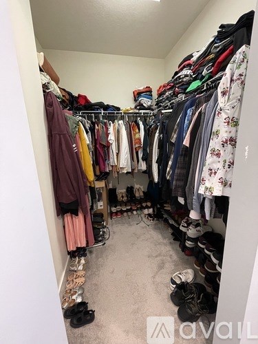 A small closet with clothes and shoes.