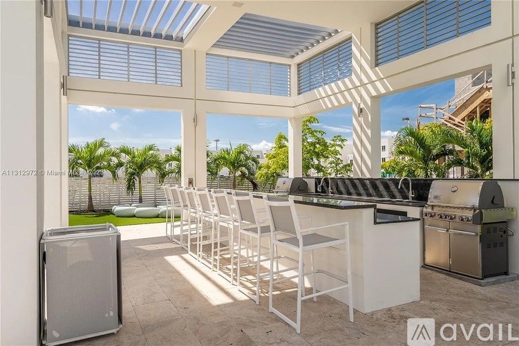 A patio with a barbecue grill and chairs.