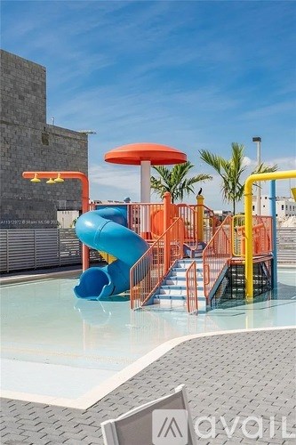 A bright orange slide and pool area with a red umbrella.