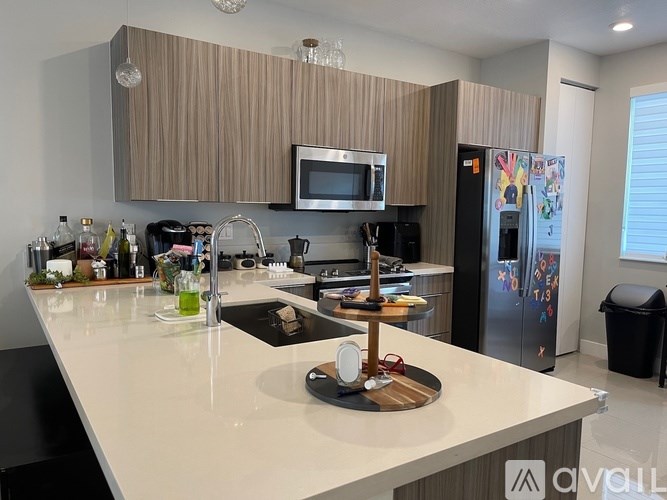 A kitchen with a white countertop and a microwave above it.