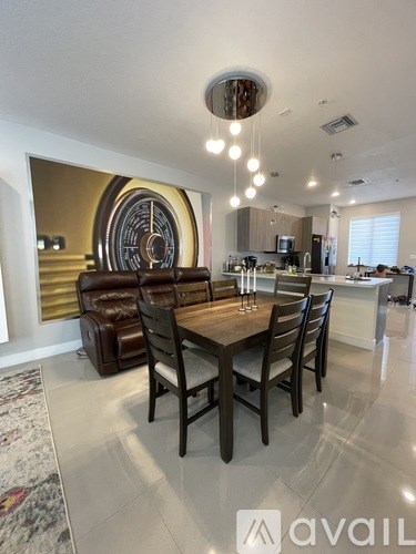 A dining room with a large table and chairs.