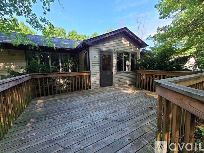 A wooden deck with a house in the background.