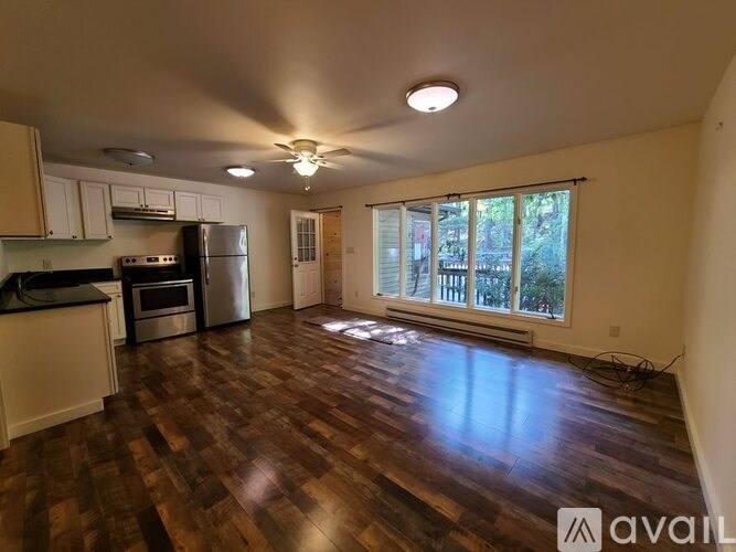A living room with a kitchen area in the background.