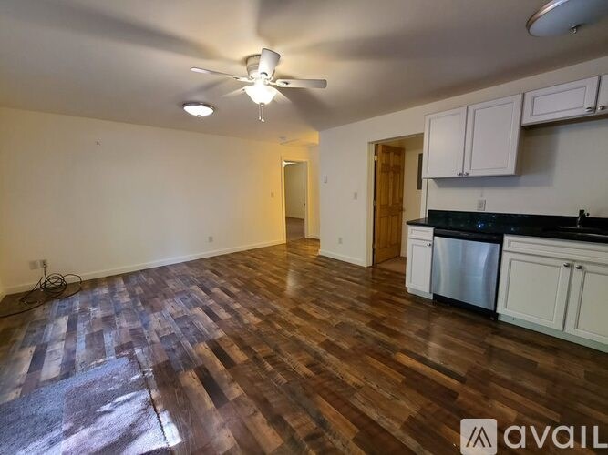 A room with wooden flooring and a ceiling fan.