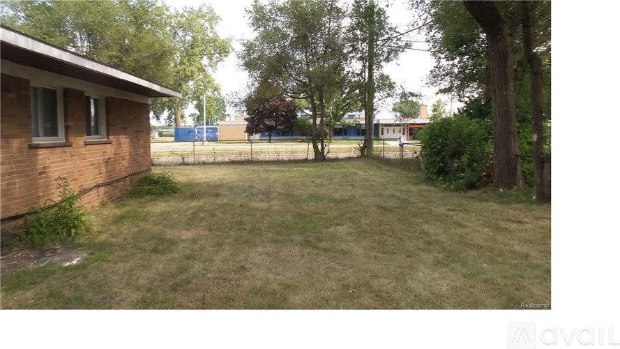 A backyard with a fence and a house.