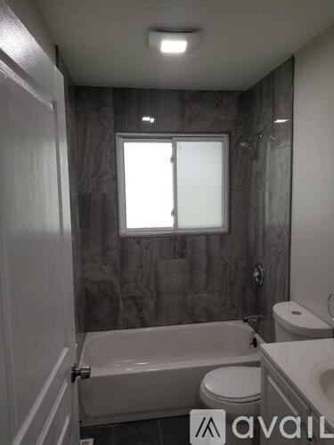 A bathroom with a tub, toilet and sink.