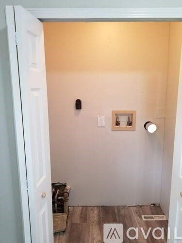 A small room with a door and a picture on the wall.