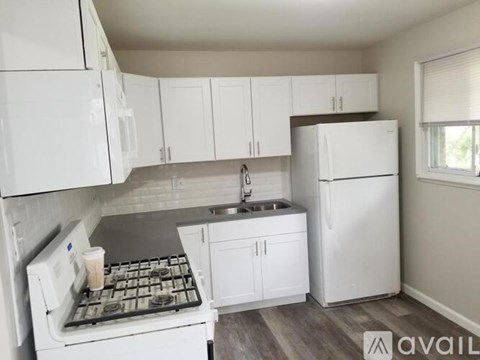 A kitchen with white appliances and cabinets.