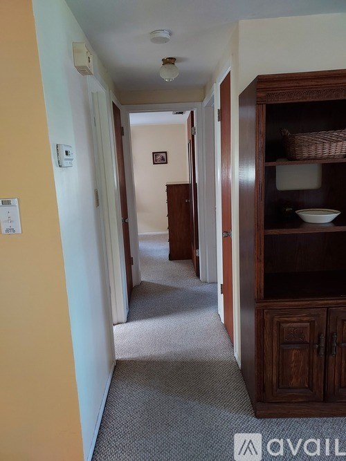 A hallway with a wooden cabinet and a basket on top.