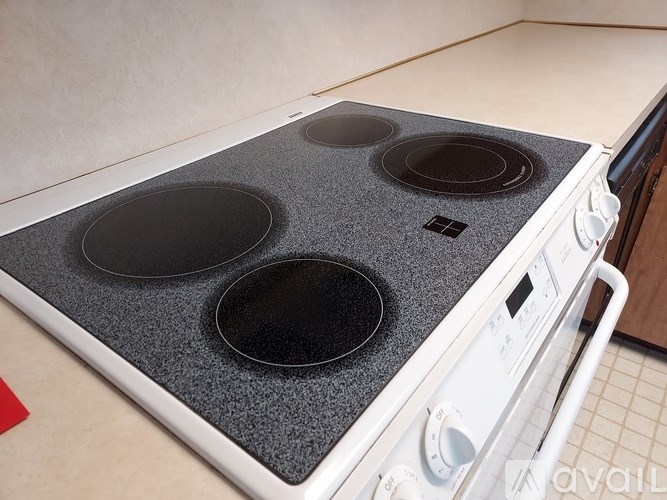 A white stove top with four burners.