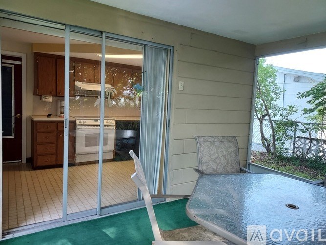 A patio with a table and chairs overlooking a backyard.