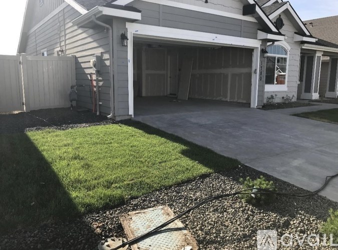 A house with a grey garage door and a white door.