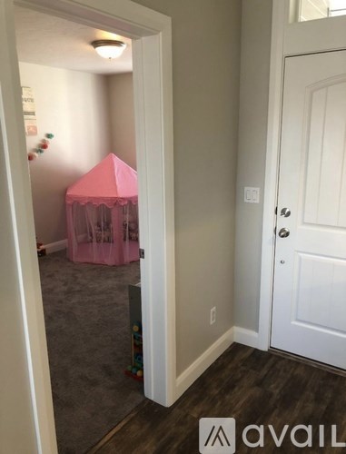 A room with a pink tent in the corner.