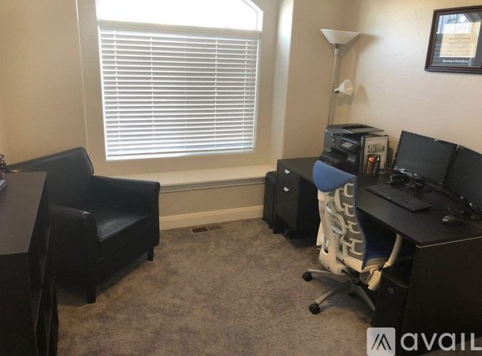 A room with a desk, chair, and computer equipment.