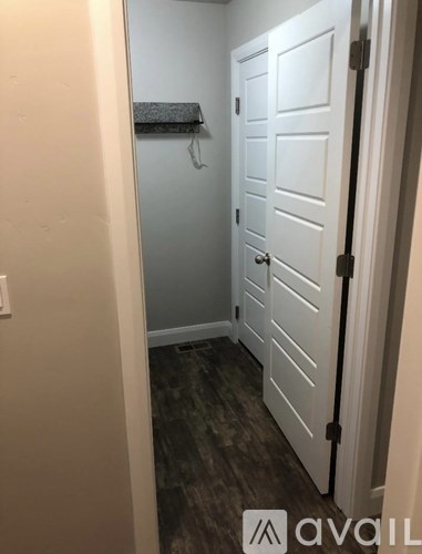 A white door is in a room with a grey wall.