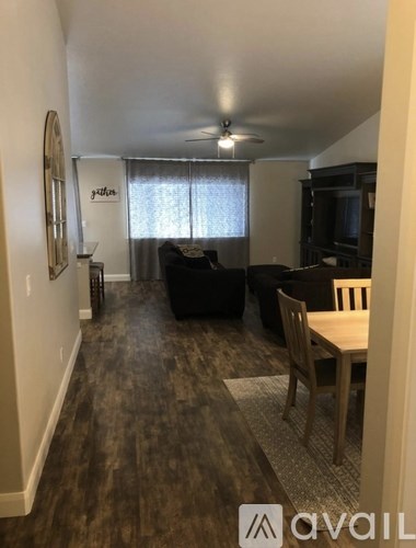 A living room with a black couch and a wooden table.