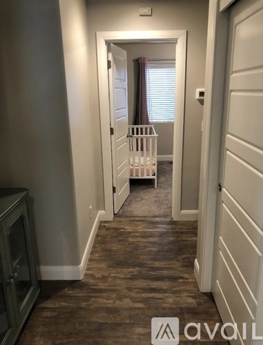 A hallway with a white door and a grey cabinet.