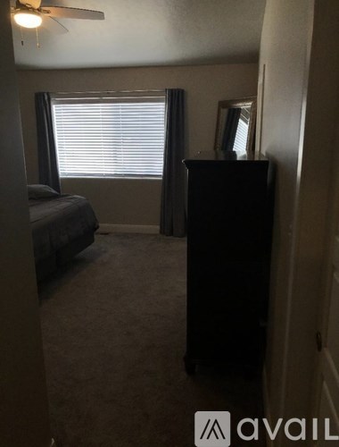 A bedroom with a bed, dresser, and window.